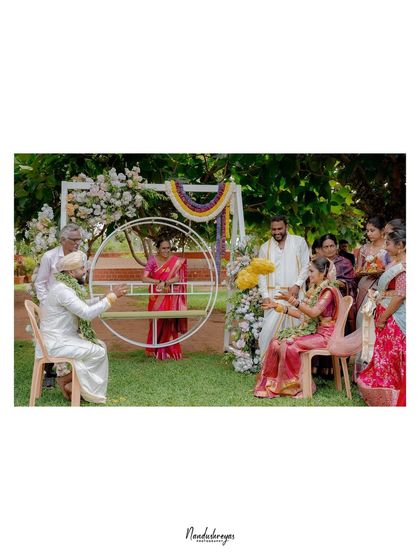 A playful ritual during the wedding, where the couple exchanges garlands. This wide shot captures the joyful atmosphere and the involvement of family.