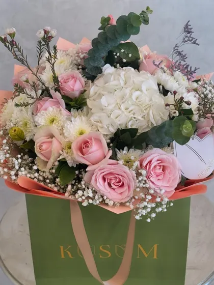 My Fleur Tote, a beautiful and practical way to gift flowers. This arrangement of soft pink roses, white hydrangeas, and delicate baby's breath looks effortlessly chic in its custom-designed bag.
