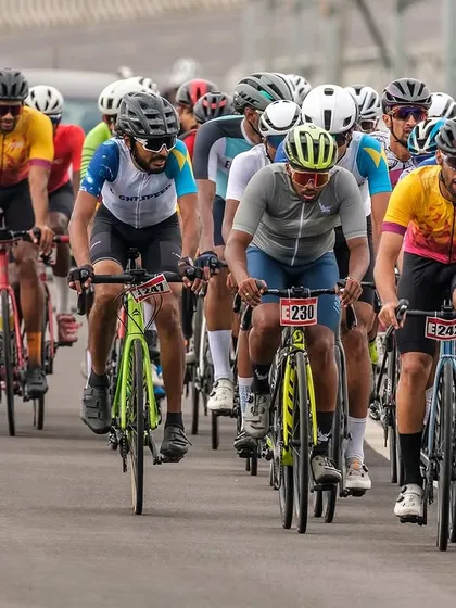 The masters peloton, a large and colorful group, rides in formation.