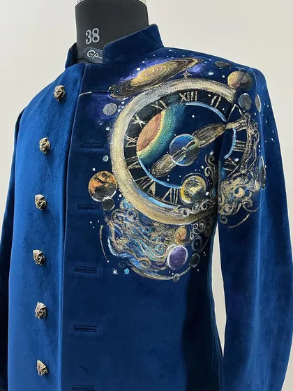 A different angle of the "Universe on Velvet" piece, showing the intricate details of the planets and cosmic clock on the shoulder of the sherwani.