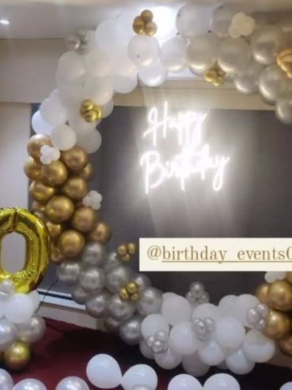 Celebrating a 50th birthday with a touch of class. This gold, silver, and white balloon ring is complemented by a large champagne bottle foil balloon.