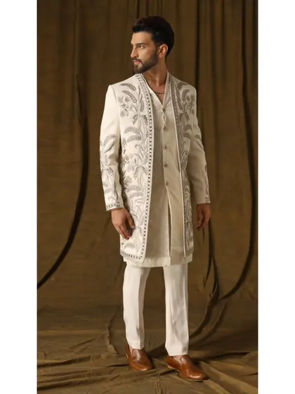 This ivory shrug set is an example of my luxury fusion wear. The open jacket, adorned with cream and gold garden-inspired embroidery, is layered over a handwoven geometric-patterned kurta for a look that is both artistic and sophisticated.