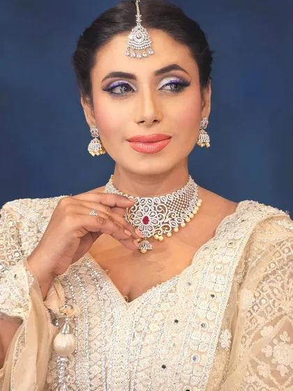 A close-up portrait highlighting the cool-toned eye makeup and diamond jewelry.