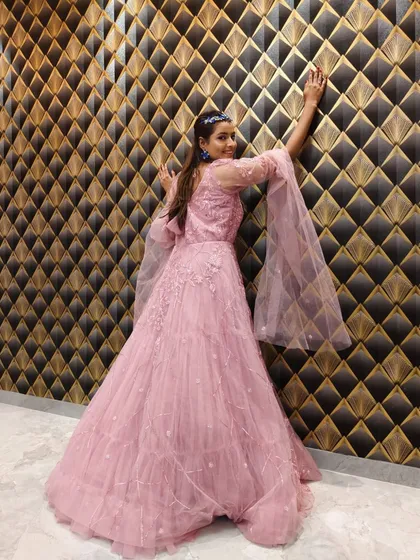 A dramatic pose in the pink gown, showing off the full skirt and sleeve details.