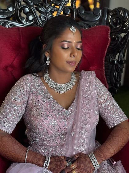 My Coimbatore bride Surya looking serene and beautiful for her reception. Her makeup features a shimmery pink eyeshadow and a flawless base, perfectly matching her pastel pink lehenga.