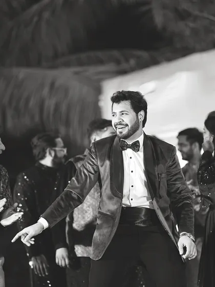 A candid moment of joy on the dance floor, captured in black and white. This is the kind of vibe that makes every Sangeet special.