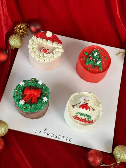A set of four adorable Christmas-themed bento cakes, featuring Santa, a Christmas tree, a wreath, and a snowman. Perfect for gifting!