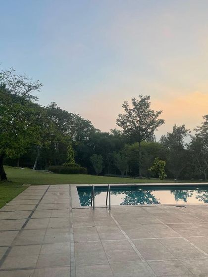 A peaceful evening view of a swimming pool at sunset.