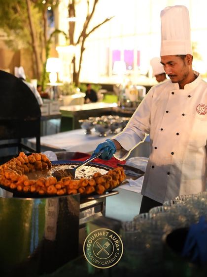 A chef at a live station, expertly frying appetizers on a large tawa. Our chefs are not only cooks but also performers who engage and entertain your guests.