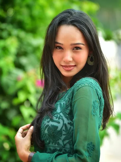 A classic portrait with a warm, friendly smile. Her direct gaze and the beautiful natural setting make this a very inviting and pretty shot.