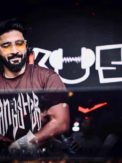 Confidence behind the console. A shot of me with my custom 'KUSH' logo on the screen behind me, owning the night.