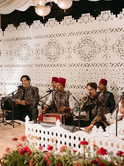 The Qawwali performers on stage, set against a custom-designed backdrop with intricate jaali patterns. The all-white theme created a serene and elegant setting for the soulful music.