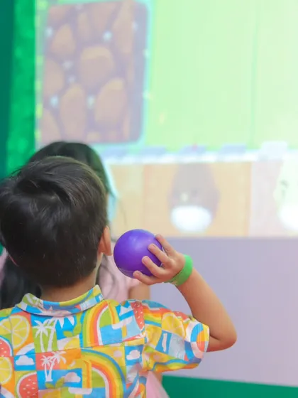 A young gamer takes aim in our interactive ball pit. This activity helps develop hand-eye coordination while being incredibly fun.