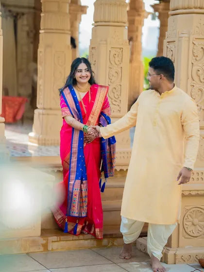 A playful and romantic shot of Shubham leading Jagruti by the hand. The soft foreground blur adds an artistic, dreamy quality to the image.
