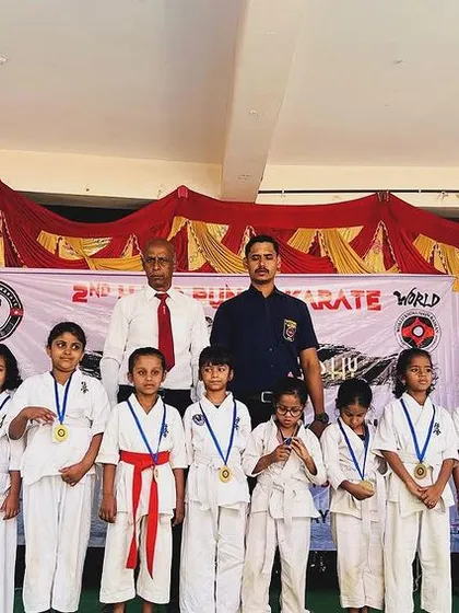 A group of our young champions proudly displaying their medals on stage. Their smiles show the joy of achievement.