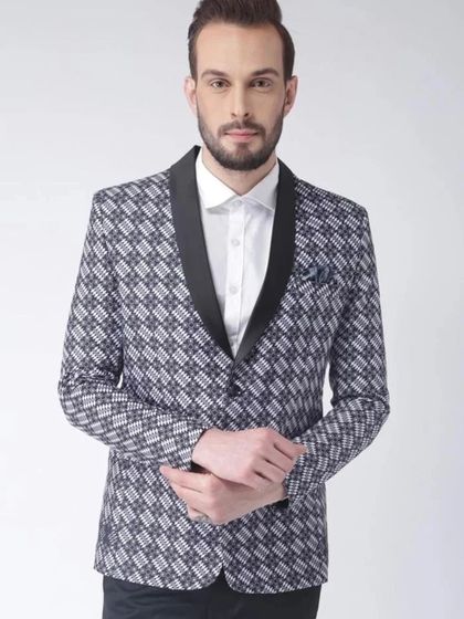 A patterned blazer with a black shawl lapel. This is a great choice for a cocktail party or sangeet, offering a more playful and fashionable alternative to a standard suit jacket.