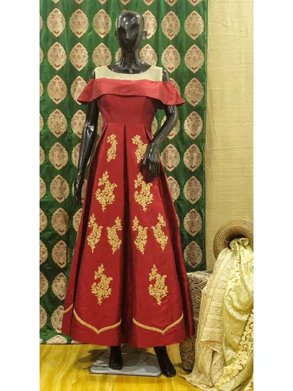 I designed this floor-length fusion gown in a rich red, featuring an elegant off-the-shoulder neckline. The skirt is adorned with delicate gold embroidery, adding a touch of traditional craftsmanship to a contemporary anarkali-style silhouette.