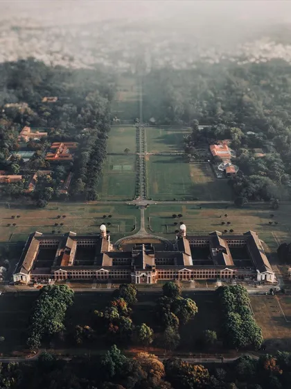 The beauty of architecture is often in its symmetry, something you can only truly appreciate from above. This top-down drone shot captures the incredible scale and design of this building surrounded by nature.