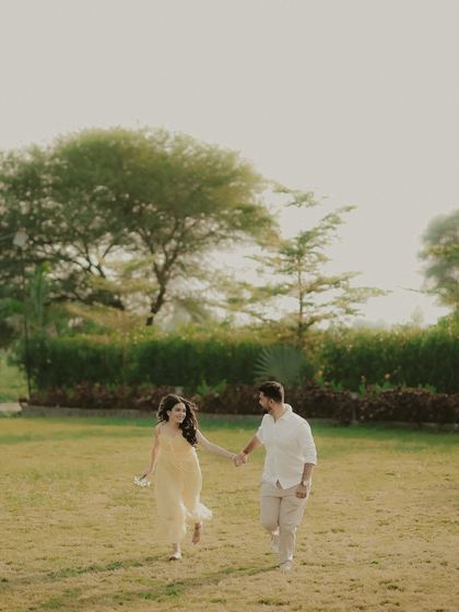 A classic romantic shot of a couple walking hand-in-hand through a park. This image captures a simple, happy moment that feels natural and unposed.