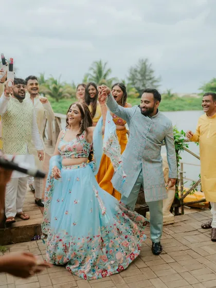 The couple makes a grand, dance-filled entrance at their Haldi ceremony, surrounded by cheering friends and family.