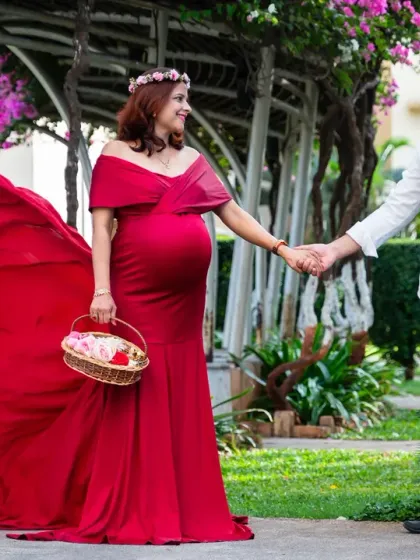 A beautiful family portrait in the making. The flowing red gown adds a touch of elegance as this couple holds hands, ready to welcome their new addition.