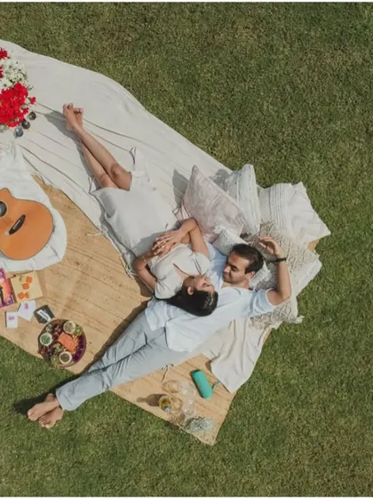 Picnics, but make them chic. This aerial view captures the full vibe of our boho-chic picnic setup, complete with soft rugs, plush cushions, a curated grazing platter, and even a guitar for the perfect afternoon.