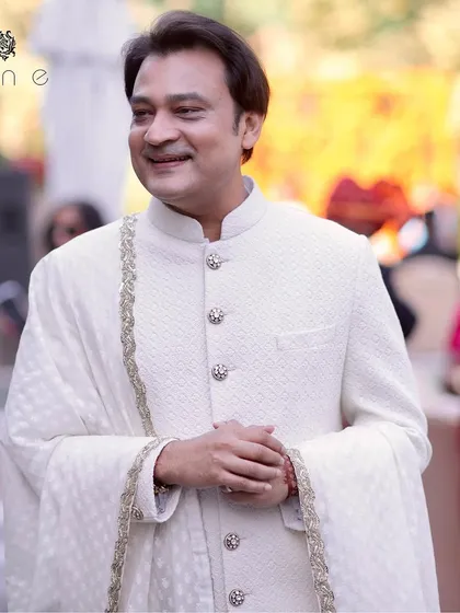 A proud groom, Saket Modi, looking dashing and regal in his bespoke ivory sherwani. We crafted this piece with a textured fabric and custom jeweled buttons to be as special as his big day.