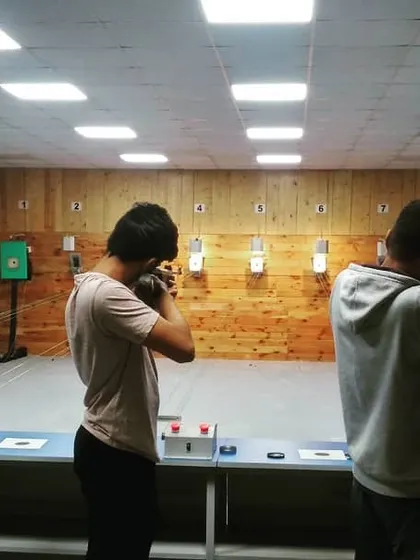 Three guests practice their aim during a recreational shooting session. Notice how each shooter adopts a stable stance to maximize their accuracy.