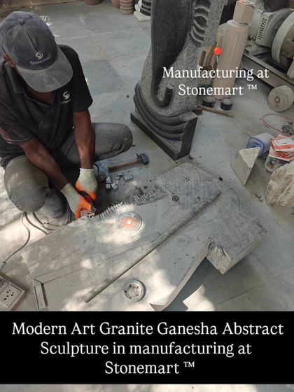 An artisan uses a power tool to carve a large, 3-foot modern art Ganesha abstract sculpture from a block of granite. This shows the initial stages of our manufacturing process.