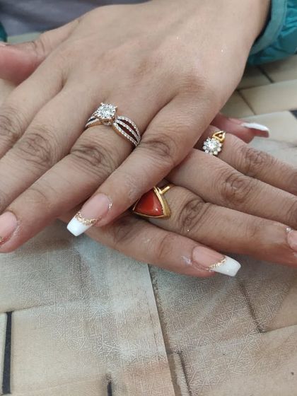 A classic white French manicure on long, square-tipped nails, accented with a delicate gold glitter line.