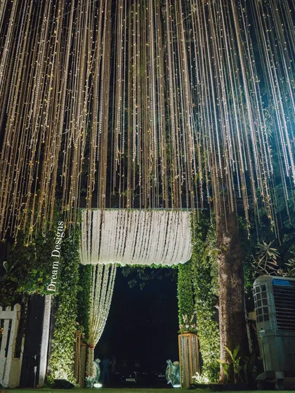 I believe a grand entrance sets the tone for the entire event. This walkway features a breathtaking curtain of cascading fairy lights and a floral chandelier, creating a truly enchanting welcome for guests.