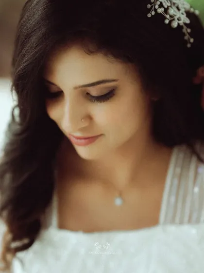 An intimate close-up of the bride, showcasing her flawless makeup, delicate jewelry, and the beautiful hair accessory that completes her look.