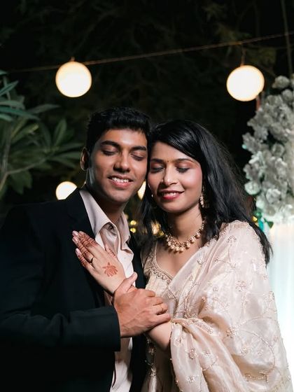 A romantic outdoor portrait of the couple under beautiful string lights, capturing the magical ambiance of their reception night.