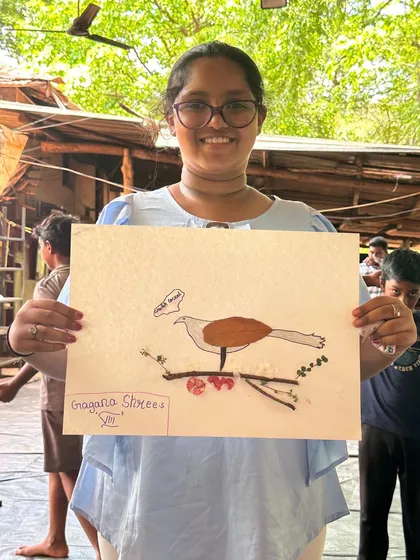 A camper proudly presents her artwork of a bird, complete with a speech bubble, showcasing the fun and creativity we encourage.