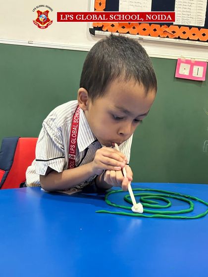 This student demonstrates focus and control as he maneuvers the ball through the play-dough course. These activities are thoughtfully designed to make learning an interactive and enjoyable process.