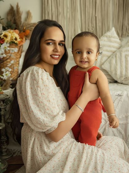 A sweet and simple portrait of a mother and her baby. Their direct gaze and gentle smiles create a classic and heartwarming image that celebrates their bond.