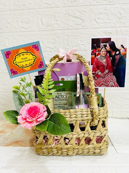 This Rakhi hamper is a complete package, including self-care items, a personalized photo, and a festive greeting card in a mesh jute basket.