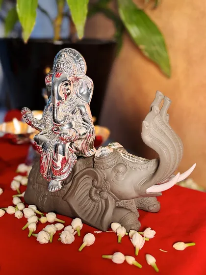 Another angle of the Ganesha on an elephant idol, showing the graceful curve of the elephant's trunk and the intricate details on its back.