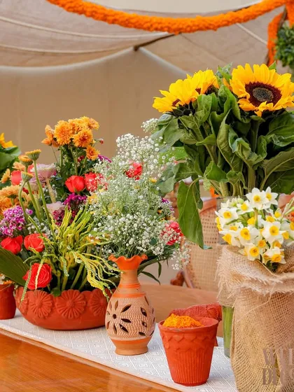 Another look at the floral arrangements on the tables. I used a variety of flowers like sunflowers, baby's breath, and narcissus in different rustic containers to create texture and visual interest.