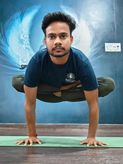 A practitioner holds a steady Tolasana (Scale Pose), lifting the body with pure core and arm strength.