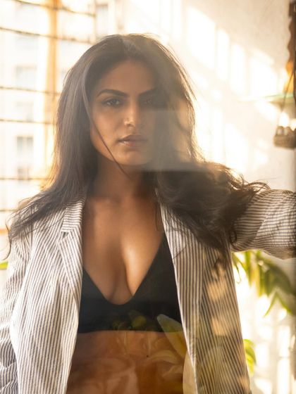 A direct-to-camera look from the same window session. The flare and reflections on the glass add an artistic, layered effect.