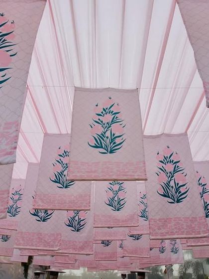 A beautiful ceiling treatment with hanging fabric panels featuring a pink block-printed floral motif, adding a soft and traditional touch.