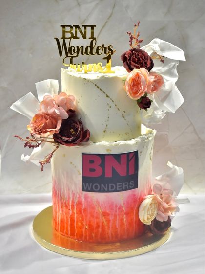 Celebrating a corporate milestone with a two-tiered cake for BNI Wonders' first anniversary. This custom cake featured layers of chocolate and fresh strawberry, decorated with their logo.