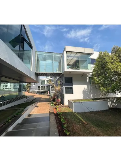 A glass-enclosed bridge connects the two linear blocks of the office campus, creating both a physical and visual link over the central courtyard.