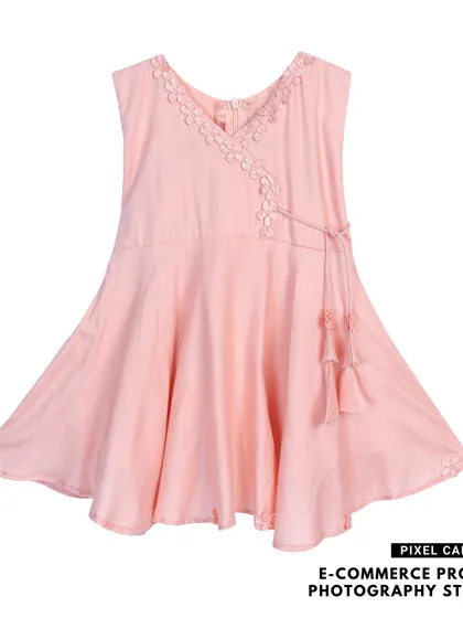 A pink baby frock with a tie-up detail, photographed flat on a white background for a clean look.