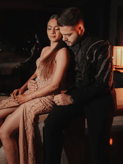 A moody and romantic portrait of a couple at their cocktail party, sharing an intimate moment.