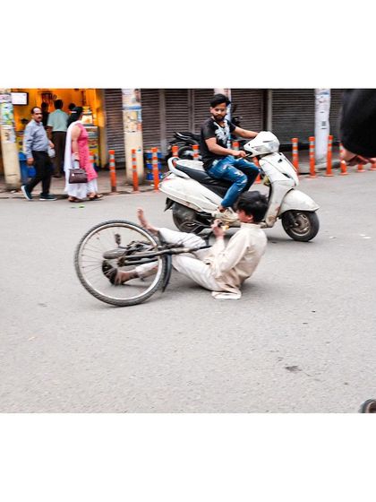 A dramatic, unplanned moment as a cyclist falls on a busy Delhi street. This image captures the unpredictable nature of street life and the split-second moments I aim to document.
