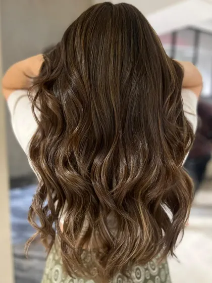 A caramel mocha highlight blend using a three-tone technique. This creates incredible depth and healthy-looking shine on long hair.