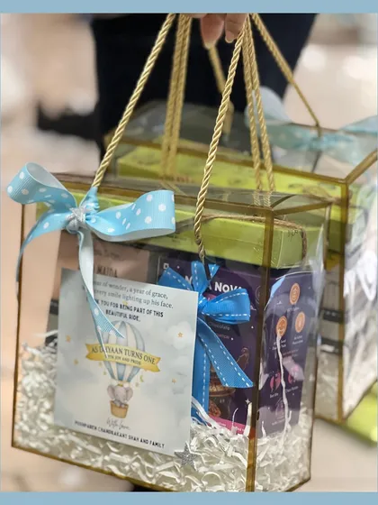 Here are the hot air balloon return favors packed in transparent handle boxes. The polka dot ribbon and custom card tie the whole dreamy theme together beautifully.