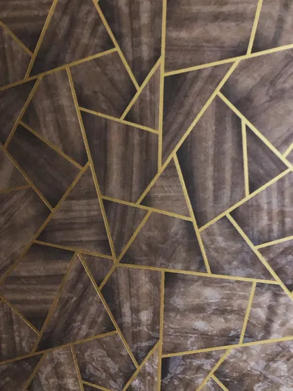 A close-up of the geometric and wood-textured wallpaper, showing the clean gold lines and the subtle texture of the material.